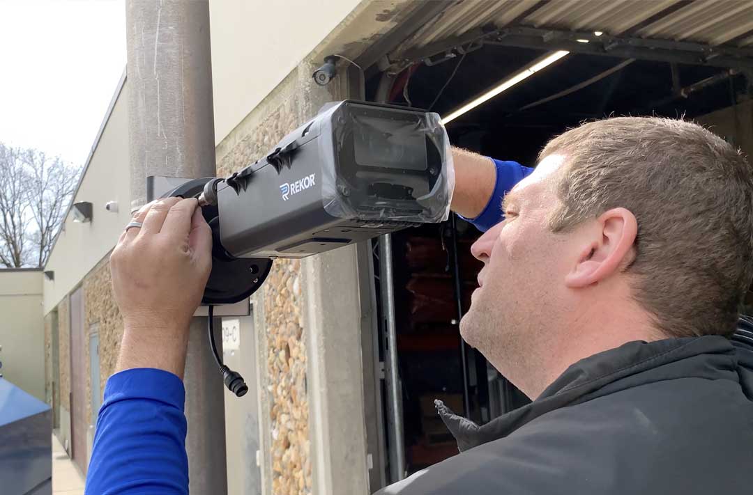 Man mounting a security camera to a pole